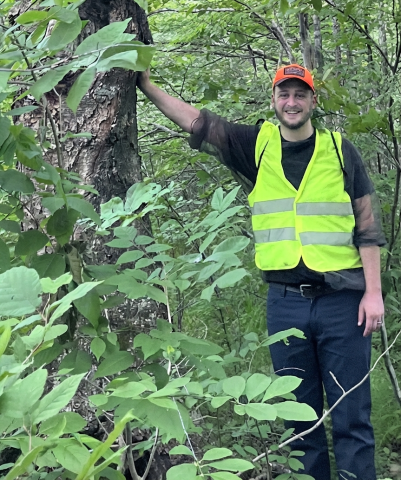 James stands next to a river birch tree